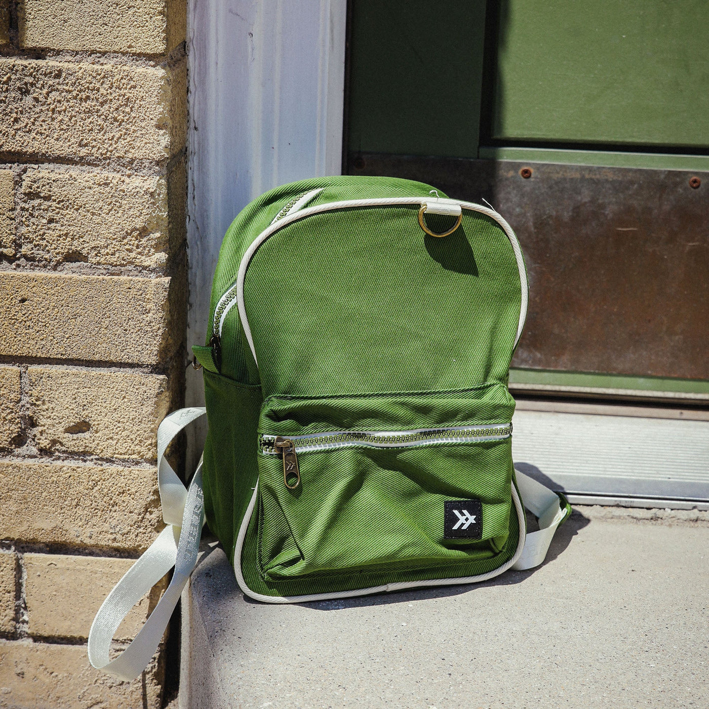 Green mini-backpack with cream trims