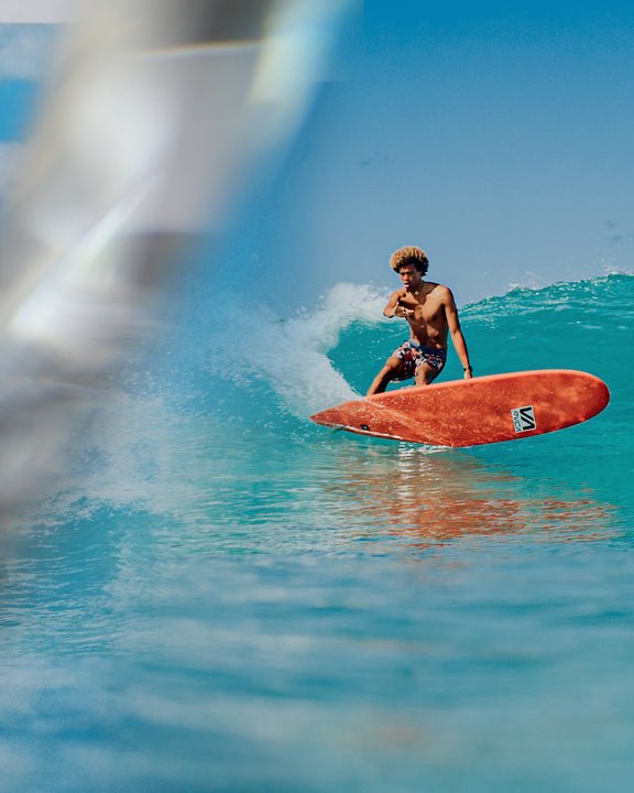 Guy surfing red longboard