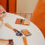 Brown leather bifold wallet with orange and white leopard print elastic